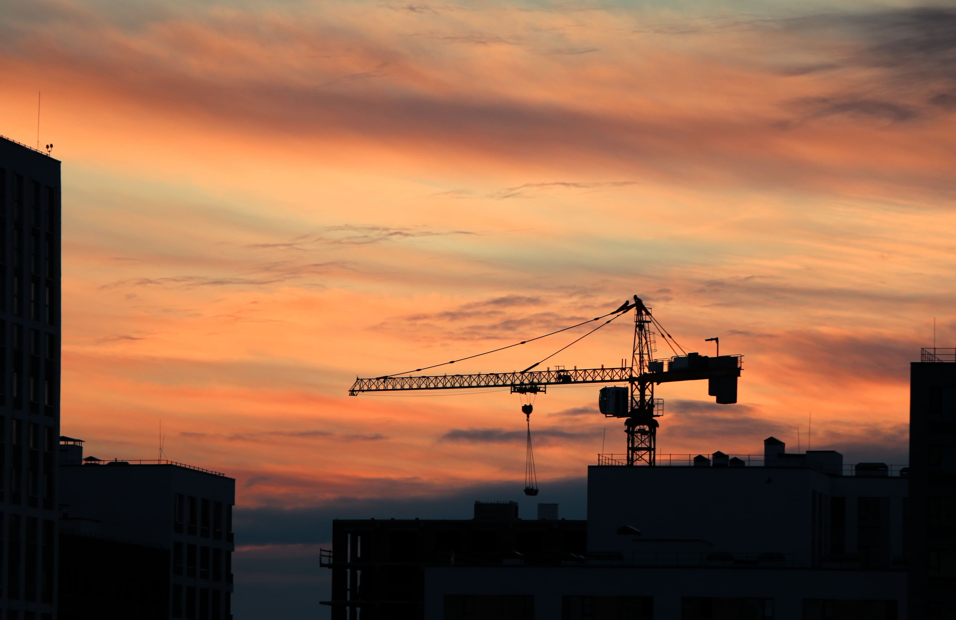 Construction cranes at sunset